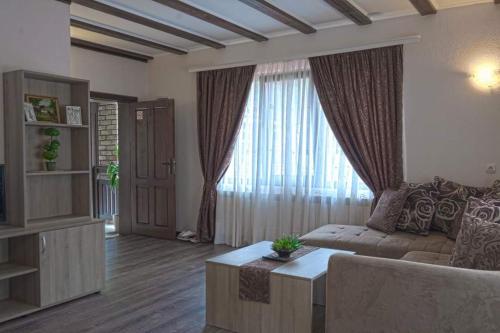 a living room with a couch and a large window at СТАР МЕРАК in Ribarica