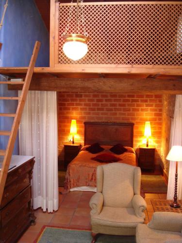 a bedroom with a bed and a ladder and a chair at Casa Gallinera in Benissiva