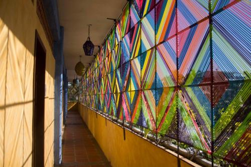 a hallway with colorful kites on the wall at Cabañas del Capitan in Rincon de Guayabitos