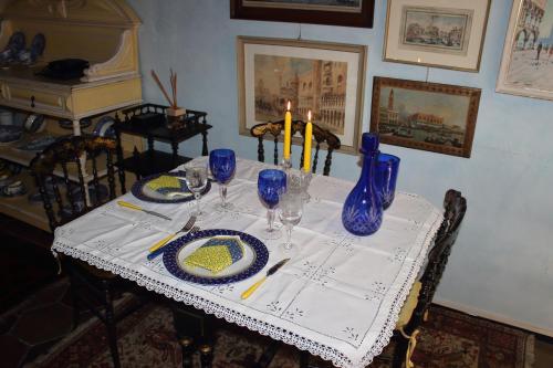 un tavolo con vasi e piatti blu e candele sopra di Penelope's House a Roma