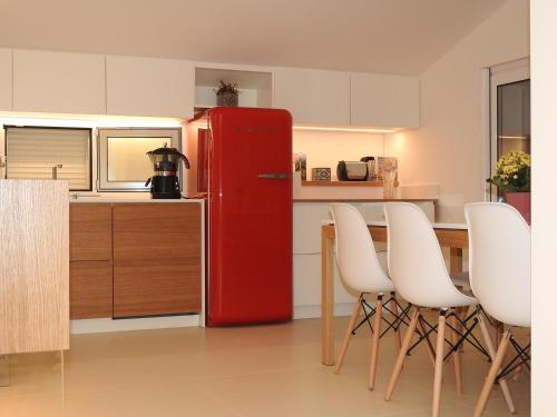 a red refrigerator in a kitchen with white chairs at Hedoné Design Experience B&B in Agrigento