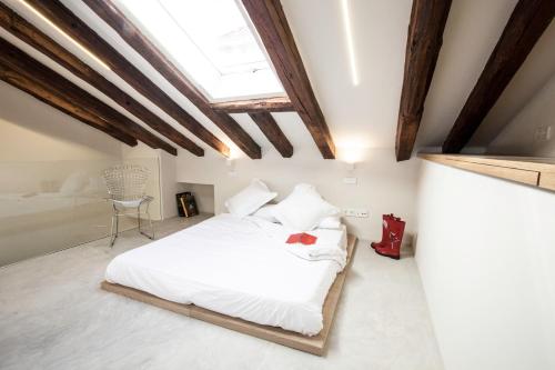 1 dormitorio con cama blanca y tragaluz en Heima Plaza Mayor - Latina 32, en Madrid