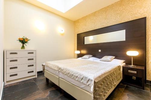 a bedroom with a bed and a dresser with a mirror at Rezidence Fontána in Teplice