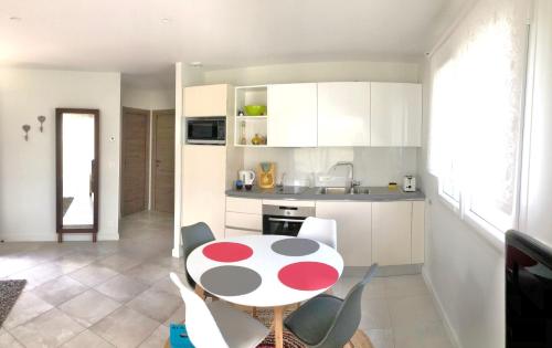 une cuisine avec une table et des chaises rouges et blanches dans l'établissement Villa Pignada, à Lanton