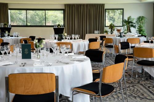 a banquet room with white tables and chairs at Best Western Plus Hotel les Rives du Ter in Larmor-Plage