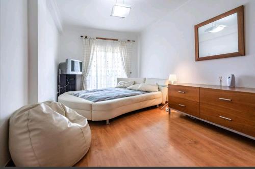 a bedroom with a bed and a dresser and a mirror at Enya in Mafra
