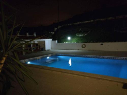 a swimming pool at night on a building at Enya in Mafra