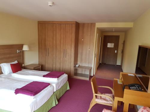 a hotel room with two beds and a table and chairs at Nashira Kurpark Hotel in Bad Herrenalb
