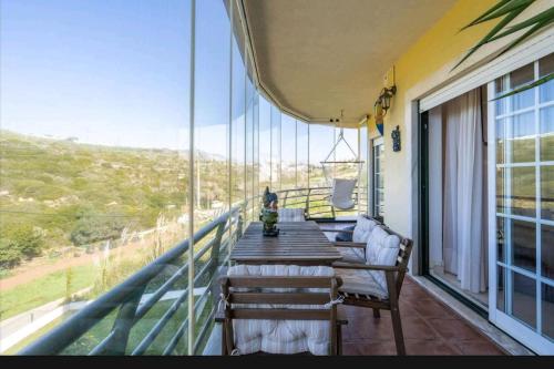 a balcony with a table and chairs and a view at Enya in Mafra