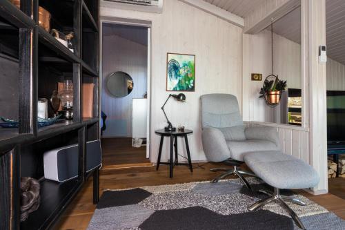 sala de estar con silla y TV en GreenKey Paradise Cabin en Selfoss