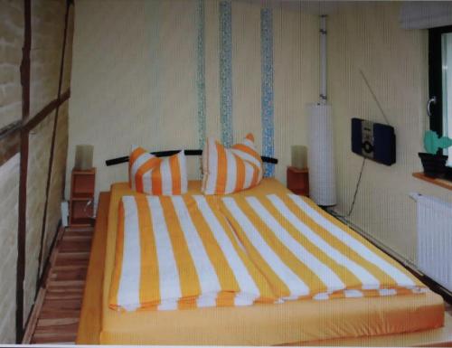 - une chambre dotée d'un grand lit avec des oreillers orange et blancs dans l'établissement Apartment - Haus Helene, à Leipzig