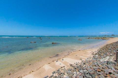 a beach with rocks and the ocean on a clear day at Pousada Pénareia in Morro de São Paulo