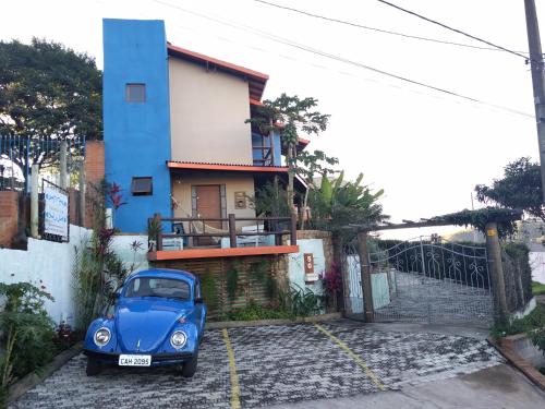 ein blaues Auto, das vor einem Haus geparkt ist in der Unterkunft Pousada Natureza e Arte in Cunha
