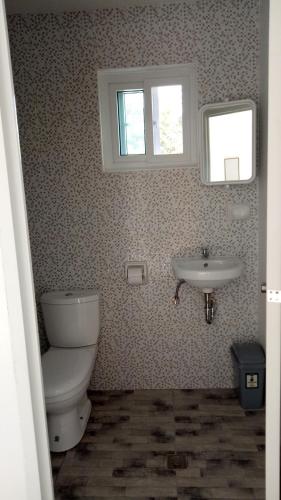 a bathroom with a toilet and a sink at Kathleens Vacation Place in Moalboal