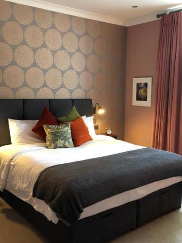 a bedroom with a large bed with colorful pillows at Moortown Lodge B&B in Ringwood