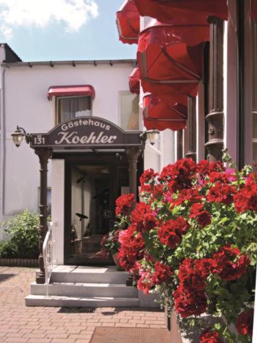 a store with a sign on the side of a building with red flowers at Hotel Köhler in Braunschweig