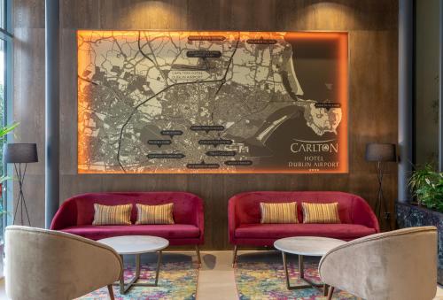 a lobby with two red couches and a map at Carlton Hotel Dublin Airport in Cloghran
