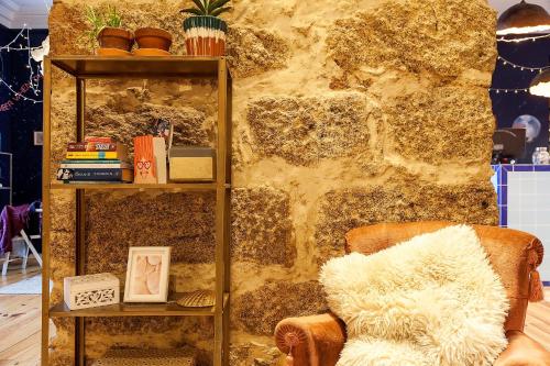 a living room with a chair and a book shelf at SUPERNOVA Hostel in Porto