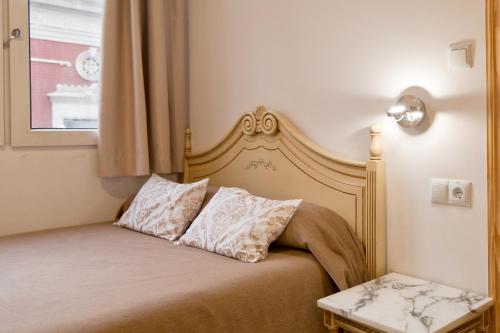 a bed with two pillows on it in a room at Hotel Marítimo Urban in Alicante