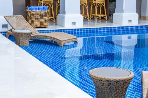 a swimming pool with chairs and a table at Casa La Merced by Mustique in Cartagena de Indias