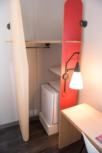 Habitación con nevera y escritorio con lámpara. en Hotel Ibis Tatui, en Tatuí