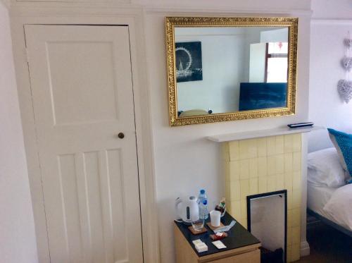 a mirror on a wall next to a fireplace at Gateway House in Didcot