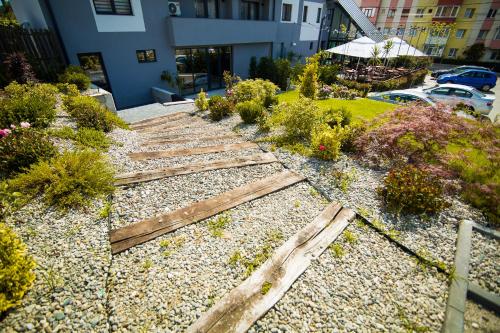 a set of wooden steps in a garden with flowers at Hotel Subcarpati in Curtea de Argeş