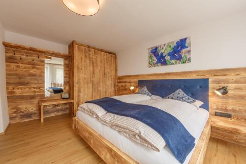 una camera con un grande letto e pareti in legno di Agriturismo MARER Urlaub auf dem Bauernhof a Villabassa