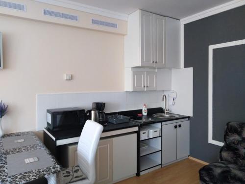 a small kitchen with a sink and a microwave at Respect Apartament in Hévíz