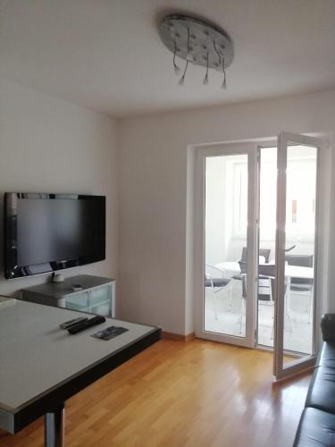 a living room with a couch and a tv and a table at Apartmani Gaj in Malinska