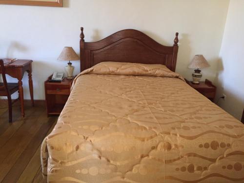 a bed in a bedroom with two night stands and two lamps at Hotel Midori in Cusco
