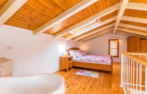 ein Schlafzimmer mit einem Bett in einem Zimmer mit Holzdecken in der Unterkunft Holiday Home Frankica in Linardići