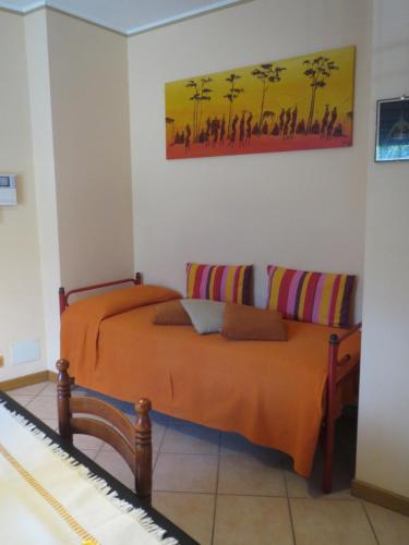een slaapkamer met 2 bedden en een schilderij aan de muur bij La Chiocciola...The Snail in Bussoleno