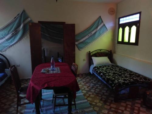 Un dormitorio con una mesa y una cama. en MAISON DU KERMA en Fez