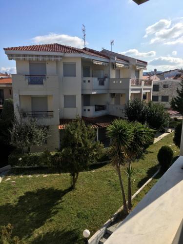 a large apartment building with trees in front of it at Stella Maisonette Hanioti in Hanioti