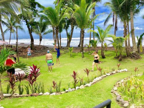 a group of people playing a game of frisbee on the beach at Hotel Beachfront Vista Hermosa in Jacó