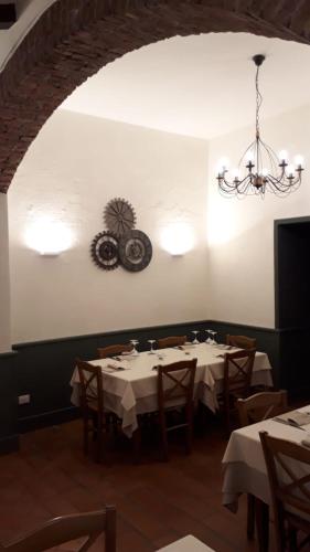 a dining room with tables and chairs and a chandelier at Locanda Capolago in Colico