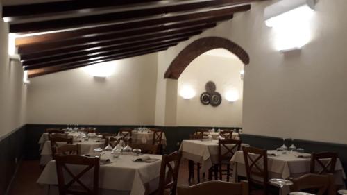 a dining room with tables and chairs with white tablecloths at Locanda Capolago in Colico