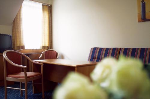a room with a table and chairs and a television at Eisenbock's Strasser Hof in Strass