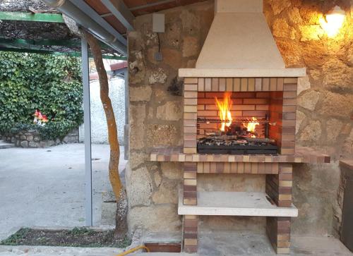 a brick fireplace with a fire in it at El Jardín de Alameda in Alameda del Valle