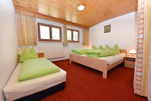 2 camas en una habitación con almohadas verdes en Landhaus Juritsch, en Klösterle am Arlberg