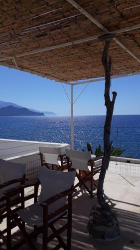 a patio with a table and chairs and the ocean at Christos Rooms in Palaiochóra
