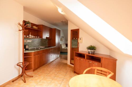 a kitchen with wooden cabinets and a table at Penzion Rondo in Bystřice pod Hostýnem
