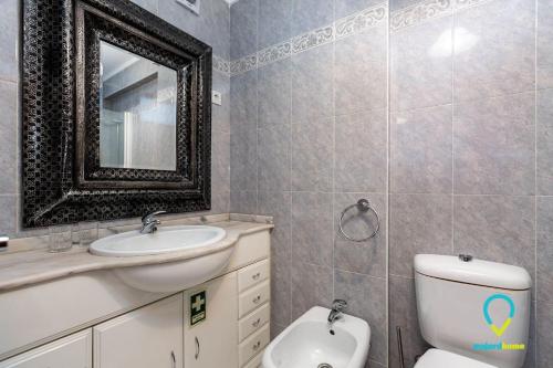 ein Badezimmer mit einem Waschbecken, einem WC und einem Spiegel in der Unterkunft Camilo Apartment in Porto