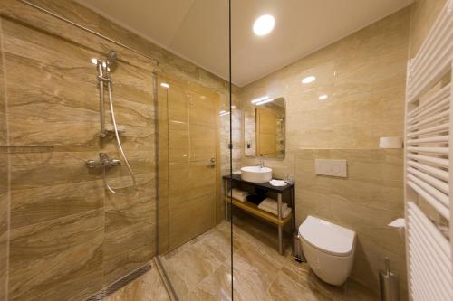 uma casa de banho com um chuveiro, um WC e um lavatório. em AZZA Hotel em Jesenice