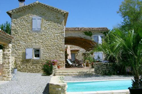 a stone house with a swimming pool in front of it at MAS DES MAGNARELLES / UZES / CEVENNES in Méjannes-lès-Alès