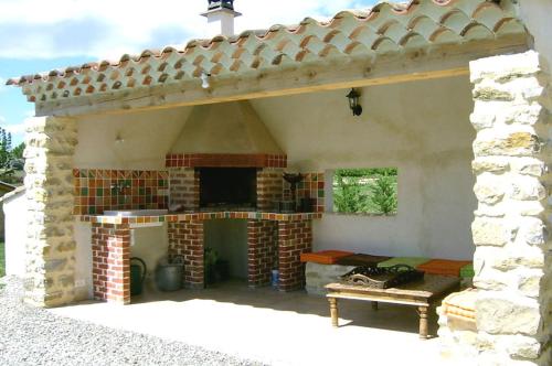 a patio with an outdoor fireplace in a house at MAS DES MAGNARELLES / UZES / CEVENNES in Méjannes-lès-Alès