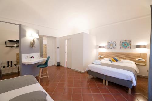 a hotel room with two beds and a desk at Residenza Normanna in Palermo