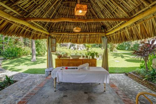a bed in a pavilion in a garden at Regis Hotel Spa in Panajachel