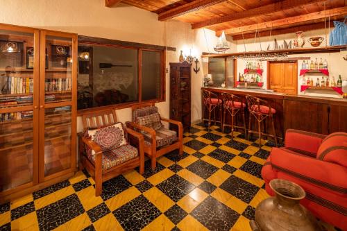 a room with a bar with chairs and a counter at Regis Hotel Spa in Panajachel